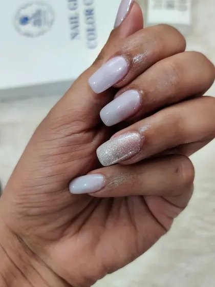 A side view of these classic nude and glitter nails, showing the clean, square shape.
