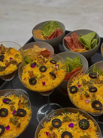 The first course of our Mexican feast: a vibrant layered dip served in individual glasses with spinach and beetroot nachos for a modern, personal touch.