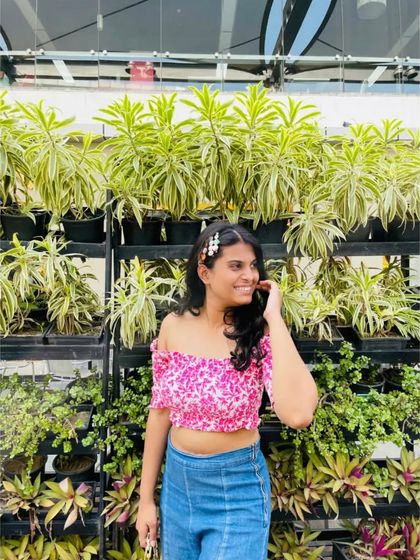 A close-up of the pink floral top and pearl hair clips. Little details like hair accessories can add a lot of personality to a simple outfit.