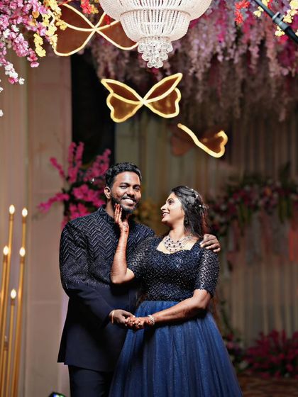 A candid moment showing how well our coordinated outfits look in action. The groom's black beaded Jodhpuri suit and the bride's navy gown are perfect for an evening of celebration.