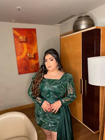 A glam goddess in this green sequin ensemble. This look is all about confidence, with a bold eye, glowing skin, and voluminous curls. Perfect for a night of celebration.