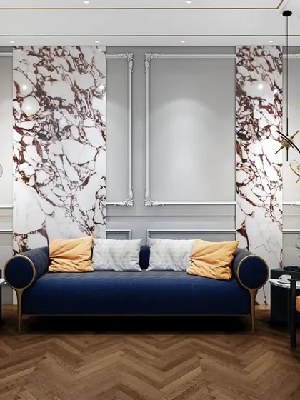 The waiting lounge for the lawyer's office features classic wall molding, dramatic marble panels, and bold furniture choices. The deep blue sofa and orange armchairs create a striking, memorable impression.