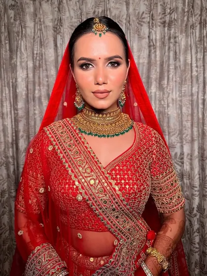 Astha’s vision came to life with our signature glam look. Glittering eyes and a majestic red-golden embroidered Sabyasachi lehenga make for an unforgettable combination.