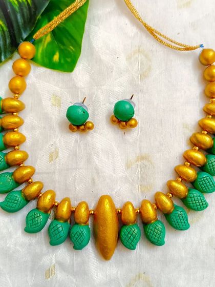 This version of the leaf-textured choker is in a refreshing sea-green and gold.
