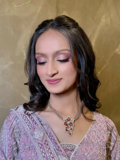 This image highlights the delicate shimmer on the eyelids and the smooth, airbrushed quality of the skin.