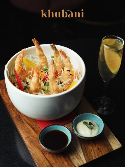 Elevate your senses with delectable flavors. This bowl of crispy tempura prawns is a symphony of taste and elegance, perfect with a crisp drink.