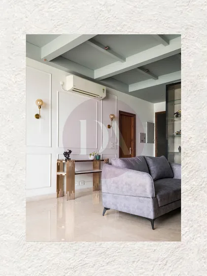 Clean lines and subtle details define this living area. We used classic wall molding and a coffered ceiling to add texture, while the simple grey sofa and gold console table maintain a sense of modern, uncluttered elegance.