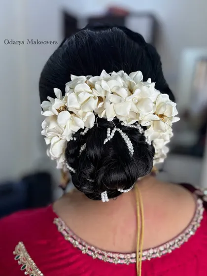 A classic floral bun for the mother of the bride for the wedding ceremony. This is a timeless and graceful hairstyle.