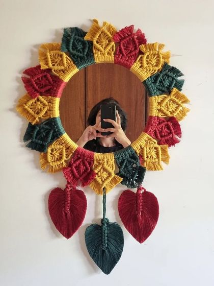 Adding a touch of artisanal flair to your walls with this stunning multicolored macrame mirror. The vibrant colors and hanging leaves make it a playful and unique piece.