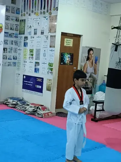 A young student stands alone on the mat, ready to begin his belt test. This moment builds immense courage and confidence.