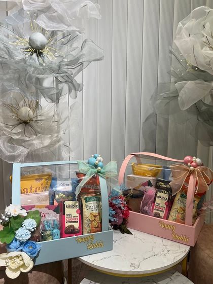 His and hers Rakhi hampers in blue and pink. These acrylic-lidded boxes are a modern and stylish way to gift your brother and sister-in-law.