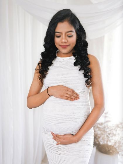 A simple, tender moment of the mom to be cradling her bump. This close up shot is all about the connection between mother and child.