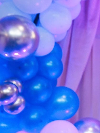 A detail shot of a blue, white, and silver balloon column, highlighting the professional decorations at the event.