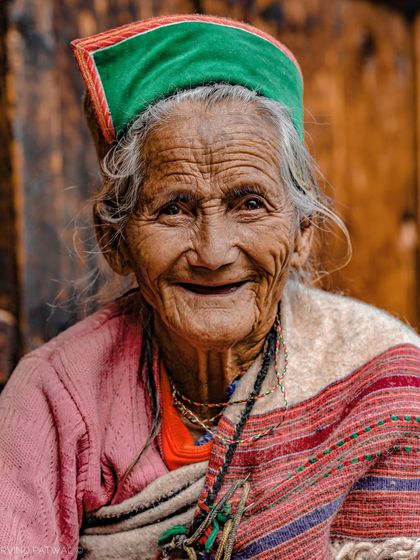 A beautiful, smiling portrait of an elderly woman from Chitkul, Himachal Pradesh. Her toothless grin and the lines on her face tell a story of a long and happy life.