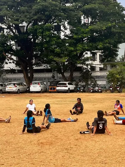 Our girls' team cooling down with some stretches after a tough practice session on the grass field.