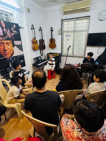 A young student performs for an audience of parents and peers at our "Musical Saturdays" open mic. This is a safe and supportive space to build stage confidence.