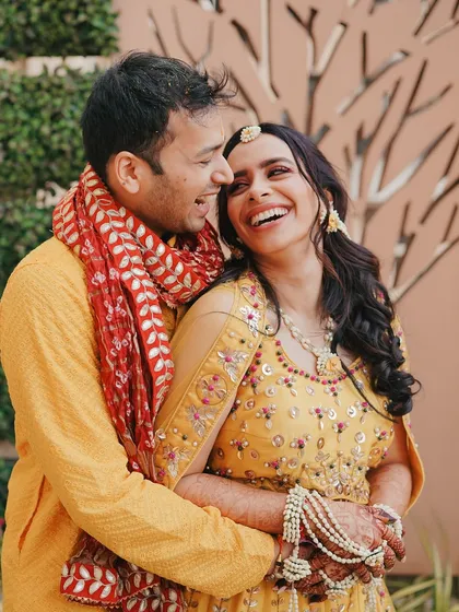A candid moment of laughter during the Haldi ceremony. The couple's genuine smiles and easy chemistry are the heart of this beautiful, natural portrait.
