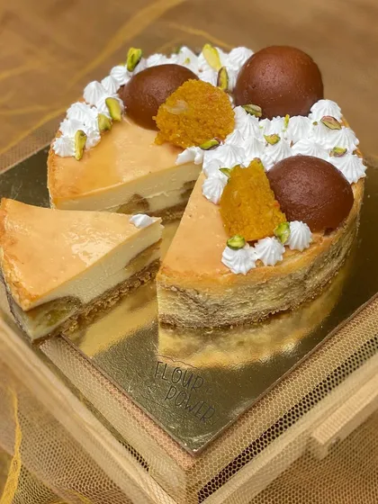 My Gulab Jamun Cheesecake is a modern twist on a classic Indian dessert. It features a creamy baked cheesecake with soft gulab jamuns nestled inside, topped with pistachios and motichoor.
