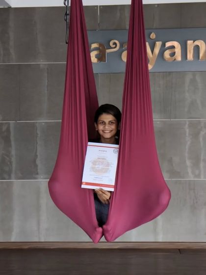 Peeking out from the comfort of the hammock, this student smiles brightly with her new teaching certificate.