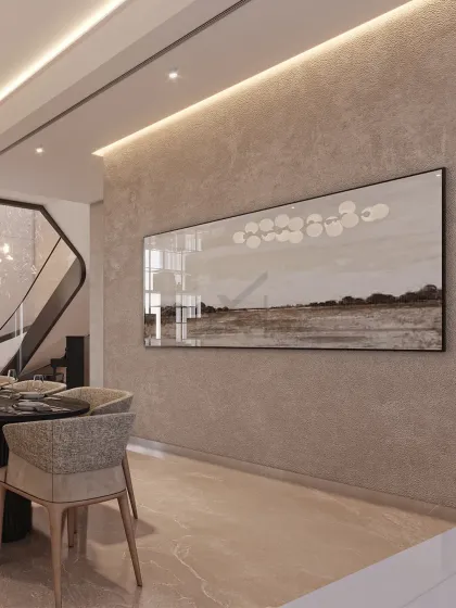 A view towards the dining area, showcasing the textured wall finish and a large piece of abstract art that complements the room's calm, neutral palette.