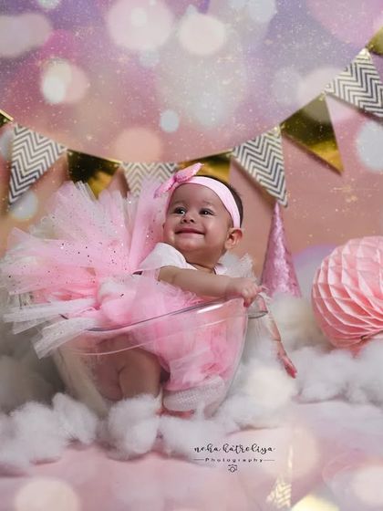 A wider view of the magical pink and gold setup. The bunting, stars, and paper lanterns all come together to create a whimsical and celebratory atmosphere for this baby photoshoot.