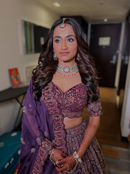 Another angle of the bride in her purple lehenga, showing the rich color and detailed embroidery.