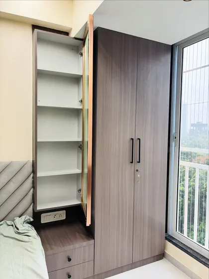 The side cabinet of the dressing unit is opened to show the deep shelving, ideal for storing toiletries and other personal items neatly out of sight.