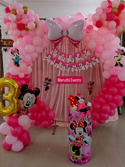A classic Minnie Mouse theme in shades of pink. This party features a large balloon arch with a Minnie bow, a themed backdrop, and a character plinth.