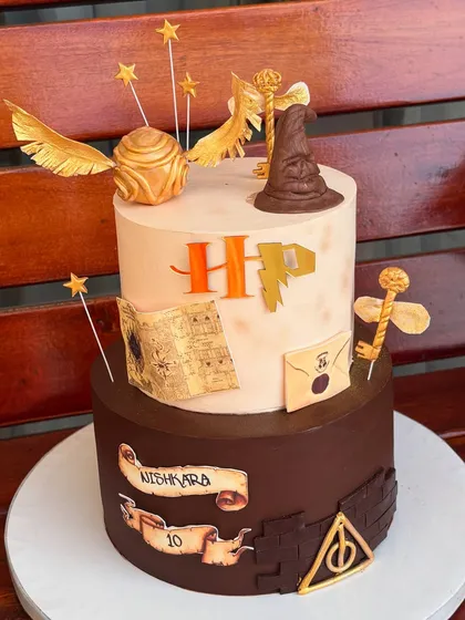 For the ultimate Potterhead, we designed this magical two-tier Harry Potter cake. It's packed with iconic, handmade fondant details like the Sorting Hat, Golden Snitch, and a letter from Hogwarts, making it a truly enchanting centerpiece.