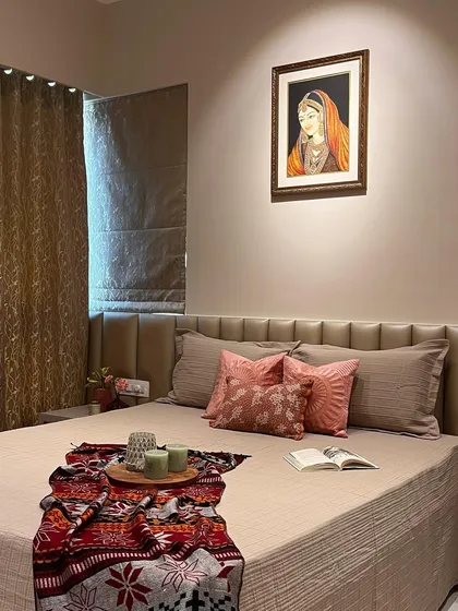 A wider view of the bedroom, showcasing the balance of colors and textures. The traditional Indian painting adds a personal and cultural touch to the modern design.