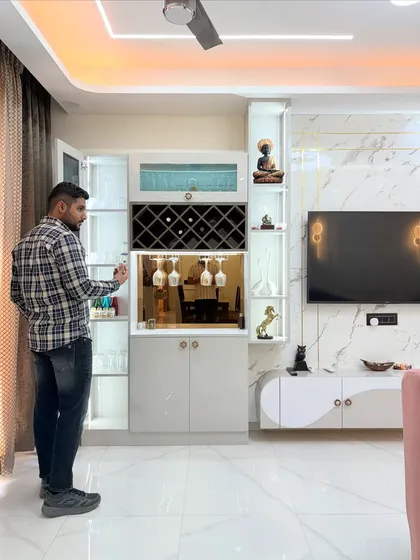 Opening the doors of the custom bar unit, which includes a wine rack, glass holders, and ample storage, all beautifully lit.