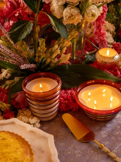 A close-up on the details. My Scented Utopia candles, with their warm glow, sit beside a delicious dessert, showing how fragrance and food can come together to create an unforgettable festive experience.