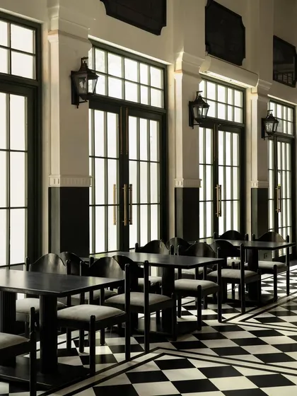 The gallery seating area, where the rhythm of the tall, dark-framed windows and classical wall lanterns creates a serene and orderly atmosphere.