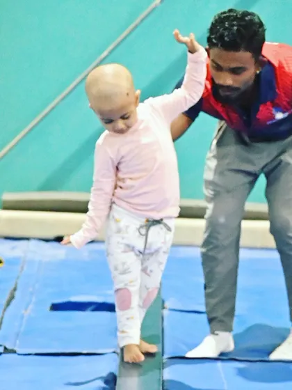 A young student shows great focus while practicing on the low beam. Our coaches are always nearby to offer a helping hand and ensure safety.