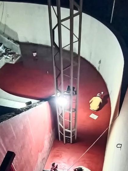 An aerial view of the amphitheater at the TAPMI Centre during construction, with artisans working late into the night to perfect the red oxide flooring.