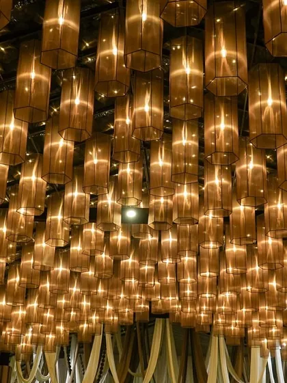 A breathtaking ceiling installation of hundreds of glowing lamps. This design creates the feeling of being under a canopy of stars, providing a truly magical and dream-like ambiance for an evening event.
