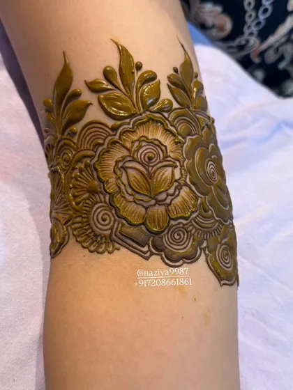A close-up of a floral arm band with 3D rose details. The shading on the petals gives it a realistic look.