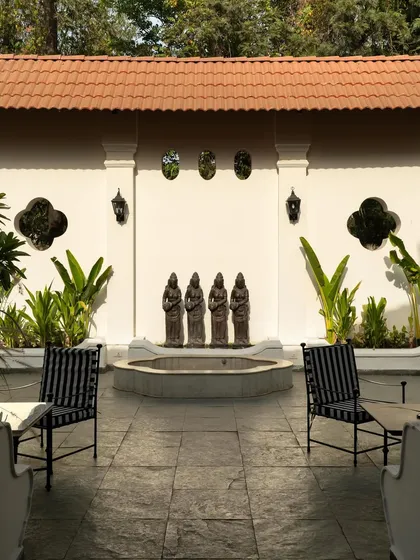 A detail of the courtyard, where a fountain and classical statues create a peaceful focal point.