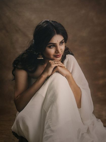 A duplicate of the seated portrait, capturing the full flow of the white saree and the model's elegant posture.