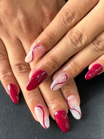 A sophisticated design with deep red nails and sheer accent nails featuring a red and white swirl pattern.