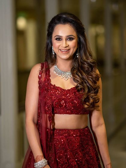 A close-up portrait of a bride, her happy smile and diamond necklace shining brightly.