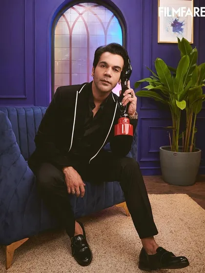 Rajkummar Rao looking dapper for Filmfare OTT in a black suit with white piping detail by Anuj Madaan. This is a great example of subtle yet impactful formalwear styling for an awards event.