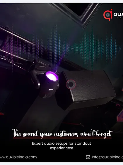 We create sound your customers will not forget. This shot captures a ceiling-mounted speaker and a purple spotlight, part of an expert audio setup designed for a standout, immersive experience in a club environment.