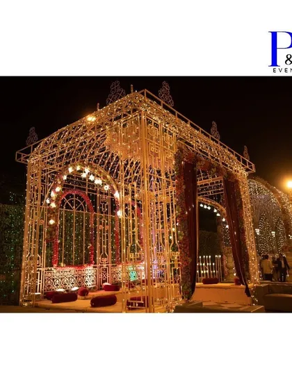 For a truly grand celebration, we design and build magnificent structures like this illuminated wedding setup. The intricate metalwork, thousands of fairy lights, and rich drapery create a royal palace ambiance for an unforgettable evening.