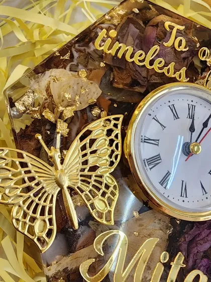 This hexagonal table clock is filled with preserved flowers and personalized with the name 'Mitali'. It's a beautiful way to add a touch of nature to your decor.
