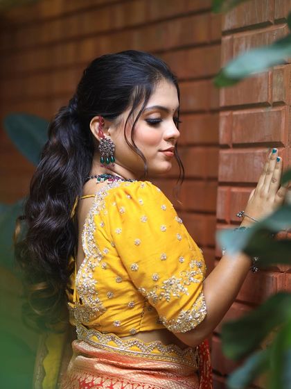 A side profile of the model, showing how the wavy ponytail beautifully complements her features.