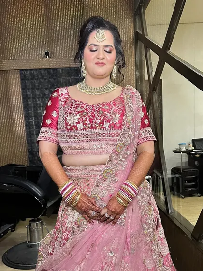 Ready for her brother's wedding. This look is all about pink tones, from her lehenga to her makeup, creating a cohesive and beautiful style.