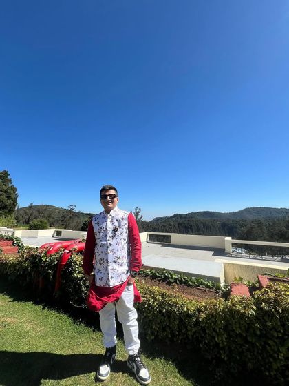 Dressed in traditional attire for a beautiful outdoor Baraat set against a stunning mountain landscape.