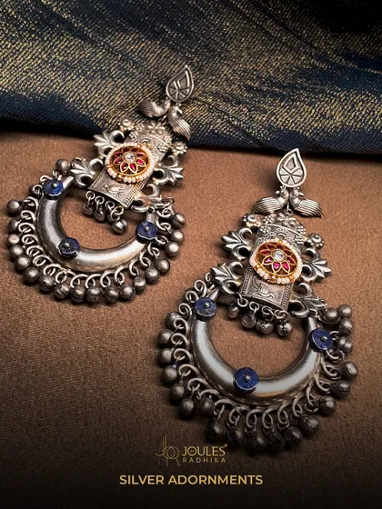 Silver Adornments. These crescent-shaped oxidized silver earrings, or chandbalis, are detailed with blue stones and silver beads for a classic, festive look.