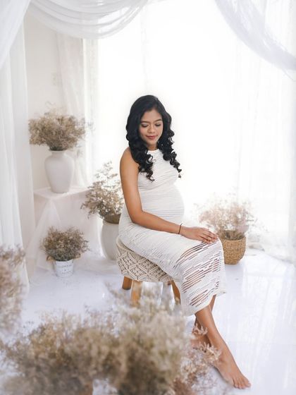 A full view of the bright and airy studio setup. The space is filled with dried flowers and soft fabrics, creating a beautiful and serene environment for the photoshoot.